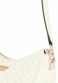Borsa a tracolla bianca trapuntata con logo dorato, caratterizzata da una superficie liscia, forma curvata e una tracolla staccabile in bianco e nero. Finiture in metallo dorato per la cerniera.