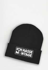 Black beanie hat featuring a ribbed texture and a frontal patch with the text "ICH HASSE MONTAGE" and a cat graphic in white and black.