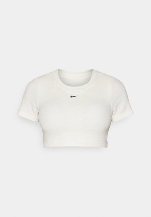 T-shirt bianca cropped in tessuto a coste, con maniche corte e collo rotondo; presenta un piccolo logo Nike nero sul petto.