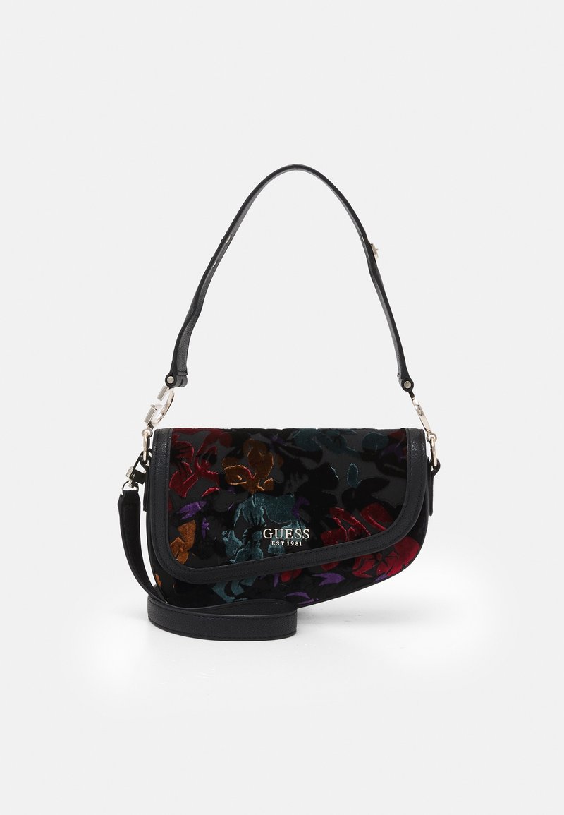 Sac à bandoulière noir Guess avec motif floral multicolore, rabat incurvé et bandoulière détachable sur fond blanc.