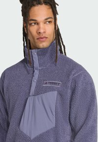 Fleece-pullover i blød, tekstureret lavendel med en halv-lynlås krave, en brystlomme i et kontrasterende materiale og et broderet logo.