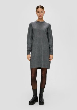Grijze gebreide jurk met lange mouwen, ronde hals en een ontspannen silhouet. In combinatie met zwarte enkellaarsjes voor een gelaagde look.