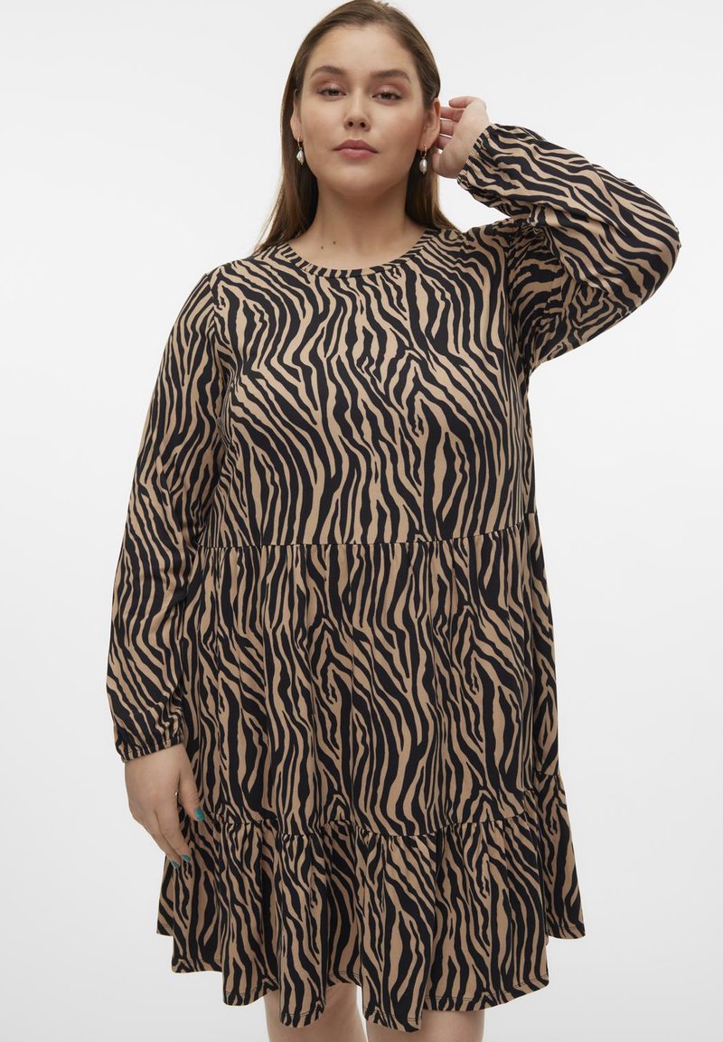 Rochie cu imprimeu zebra, cu mâneci lungi, decolteu rotund, țesătură texturată bej și tiv cu volane în paturi. Are un contrast de culori între negru și bej.