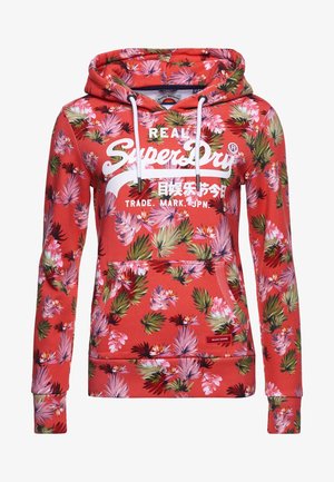 Sweat à capuche corail rose avec imprimé floral tropical rose et vert, cordons blancs, poche kangourou, et logo blanc "SuperDry" avec texte japonais à l'avant.