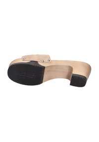 Houten platform schoen met een beige suède bovenwerk, voorzien van een zwarte rubberen zool met een gestructureerde grip en decoratieve accenten van zilverhardware.