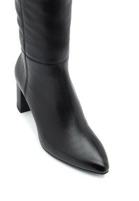 Czarne skórzane kozaki do kolan z wydłużonym noskiem, słupkowym obcasem, gładką teksturą i subtelnymi detalami w postaci przeszyć wzdłuż boku.