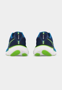 Ζευγάρι μπλε και πράσινα παπούτσια για τρέξιμο, φωτογραφημένα από πίσω, σε λευκό απλό φόντο.