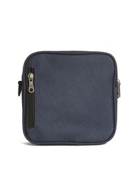Piccola borsa in tessuto blu navy con cerniera argentata sul lato anteriore sinistro e bordi arrotondati su sfondo bianco.