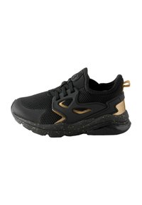 Chaussure de sport en mesh noir avec accents dorés, semelle en caoutchouc texturé et un design découpé unique sur le côté. Comprend un col rembourré et des lacets.