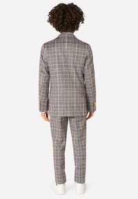 Completo grigio a scacchi con vestibilità ampia caratterizzato da un motivo scozzese multicolore. Composto da un giubbotto doppiopetto e pantaloni abbinati.