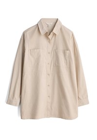 Beige button-up shirt with long sleeves, two front pockets, and a standard collar. Made of a soft, textured fabric.