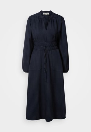 Navy blauwe jurk met verticale streepjes, lange mouwen, geplooide halslijn en een met een riem omklede taille. Bevat twee voorzakken.