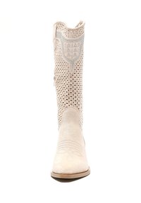 Botas de cowboy de cuero blanco con diseño perforado, punta afinada, costuras decorativas y acentos metálicos en el eje superior.