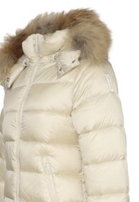 Giacca a vento in beige chiaro con cappuccio foderato in pelliccia. Il design presenta una texture trapuntata e tasche laterali con zip. Dettagli includono bottoni sul colletto.