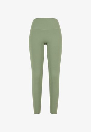 Rohelised retuusid venivast kangast; kõrge talje disain, kehaümberpõtva kuju ja sile tekstuur, ilma nähtavate õmbluste või mustriteta.