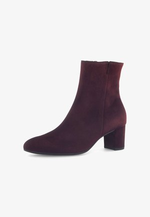 Burgundy suede ankle boot with a rounded toe, block heel, and a smooth texture. Zipper closure at the back for easy wear.