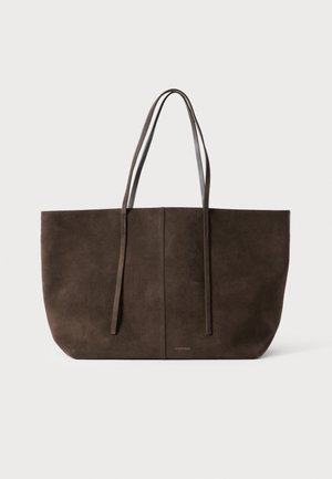 Ruda zomšinė rankinė su ilgomis odinėmis rankenomis, minimalistiniu dizainu ir į centrą išdėstytu siūleliu. Apačioje subtiliai matomas logotipas.