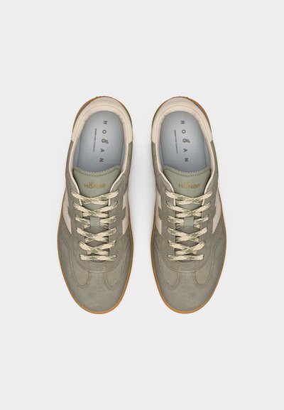 Ζευγάρι γκρι σουέντ αθλητικά παπούτσια με μπεζ κορδόνια, λευκό λογότυπο στο πλάι και καφέ λαστιχένιες σόλες, σε θέαση από πάνω σε ανοιχτό φόντο.