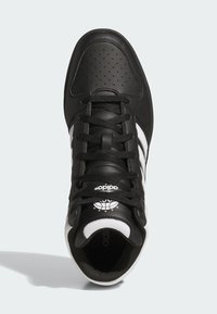 Czarne sportowe buty z perforowaną skórzaną cholewką, białymi trzema paskami i czarnymi sznurowadłami; zawierają logo i siateczkowe akcenty na języku.