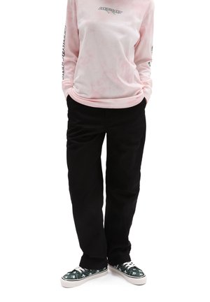 Chemise à manches longues tie-dye rose avec logo, pantalon noir et baskets à motifs verts avec semelles blanches. Caractérisée par une coupe décontractée.