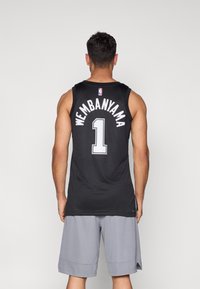 Tricou negru de baschet cu inscripția "WEMBANYAMA" și numărul "1" în alb pe spate; asortat cu pantaloni scurți gri, materialul pare respirabil.