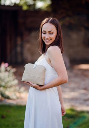 Beige synthetic handbag with a smooth texture, rectangular shape, and a top zipper closure. Features a subtle logo and adjustable shoulder strap.