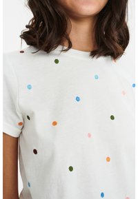 Witte katoenen t-shirt met meerkleurige geborduurde stippen in blauw, roze, oranje, groen en bruin. Korte mouwen en ronde hals.