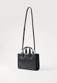 Sac à main noir en matériau synthétique texturé. Dispose de deux poignées courtes et d'une longue bandoulière réglable. Forme rectangulaire avec finition brillante.