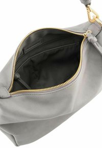 Sac à main en cuir gris clair avec une fermeture éclair dorée, ouvert pour montrer un intérieur en tissu noir et une poche zippée intérieure.