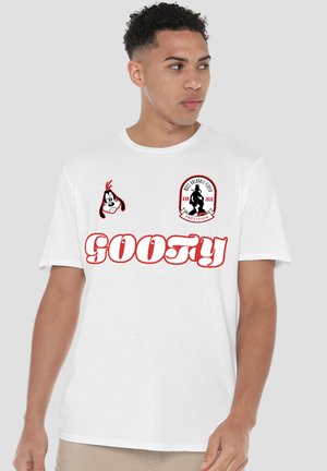 Man wearing white T-shirt with red "Goofy" text, Disney character Goofy's face, and a silhouette patch on chest.