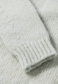 Hellgrauer, gestrickter Pullover mit strukturiertem Muster und gerippten Bündchen, aus weichem Wollmaterial gefertigt. Der Stoff wirkt gemütlich und dick.