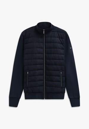 Marineblauer gepolsterter Jacke mit Stehkragen, Reißverschluss und Seitentaschen. Mit strukturiertem gesteppter Vorderseite und einfarbigen Ärmeln.