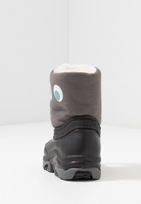 Botte grise avec doublure en fausse fourrure blanche et accents turquoise. Semelle en caoutchouc et partie inférieure noire texturée pour une meilleure adhérence.