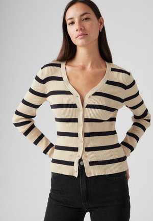 Beige en marineblauwe gestreepte cardigan, geribbelde textuur, V-hals, knoopsluiting aan de voorkant, lange mouwen, aansluitende silhouet, gecombineerd met donkere jeans.