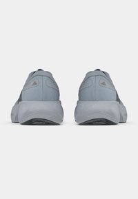 Γκρι αθλητικά παπούτσια με λείο ύφασμα επάνω, λαστιχένια σόλα και μαλακό, στρογγυλεμένο σχέδιο στη φτέρνα με διακριτικές λεπτομέρειες.