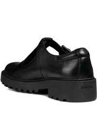 Zapatos de cuero negro con lados recortados, suela de goma gruesa y acabado texturizado. Presentan un logo en relieve "GEOX" en el tacón.