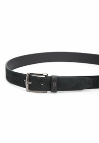 Zwarte suède riem met een zilveren metalen gesp en leren accenten. Heeft een gladde textuur, subtiele gaten voor aanpassing en een strakke uitstraling.