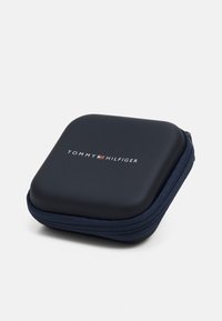 Funda dura de color navy con un acabado suave, cierre de cremallera y el logo "TOMMY HILFIGER" en blanco, situado de manera central en la parte superior.
