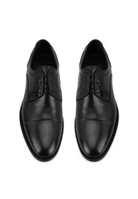 Zwarte leren dresschoenen met een gladde afwerking, ronde neus en vetersluiting met vijf oogjes. Kenmerkt zich door het cap-toe ontwerp en subtiele accenten aan de zijkanten.