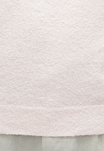 Ροζ ανοιχτό υφασμάτινο με υφή και χνουδωτή επιφάνεια. Το κάτω τελείωμα έχει λείο, ανοιχτό μπεζ χείλος. Απλός, απαλός σχεδιασμός.