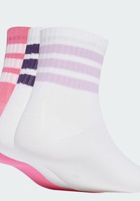 Tres pares de calcetines: rosa con rayas blancas, púrpura con rayas blancas y blanco con rayas púrpuras. El material es suave y de punto.