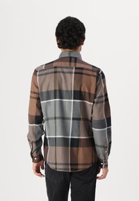 Καφέ και γκρι καρο πουκάμισο με γκρι γιακά, κουμπωτές μανσέτες και καμπύλη κάτω άκρη. Το ύφασμα έχει μαλακή υφή και άνετη εφαρμογή.