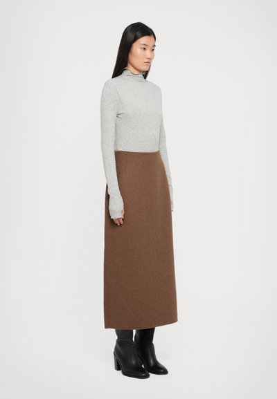 Grey long-sleeve turtleneck top paired with a brown mid-length skirt, worn with black heeled ankle boots. Smooth textures and fitted design.
