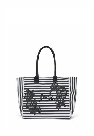 Sac fourre-tout à rayures noires et blanches avec poignées noires, appliques de dentelle florale et logo en écriture cursive au centre avant.