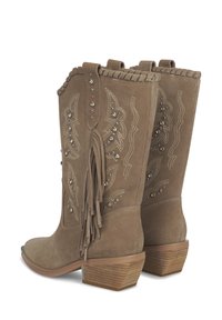 Botas de vaquero de ante marrón con un tacón bajo apilado, flecos decorativos, detalles de tachuelas y patrones de costura intrincados en los laterales.