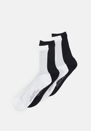 Vier Paare Baumwollsocken in Schwarz und Weiß, mit strukturiertem Rippdesign und kontrastierenden Farben, sowie verstärkten Fersen- und Zehenbereichen.