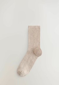 Beigenvärinen ribbineulosukka, jossa on pehmeä rakenne, vahvistetut kantapää ja varvasosa sekä sileä resori yläosassa.