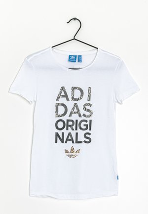 T-shirt bianco in cotone con maniche corte. Presenta grafiche nere spesse e a fantasia con la scritta "ADIDAS ORIGINALS" e il logo.