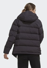 Black puffer jacket with a hood, featuring a quilted design, elastic cuffs, and adjustable hem. Material appears lightweight and warm.