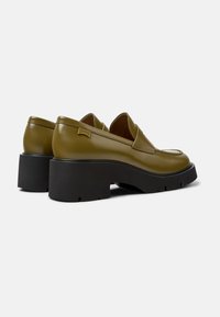 Olive green patent leather loafers with a chunky black rubber sole and subtle stitching detail. Features a branded tag on the side.